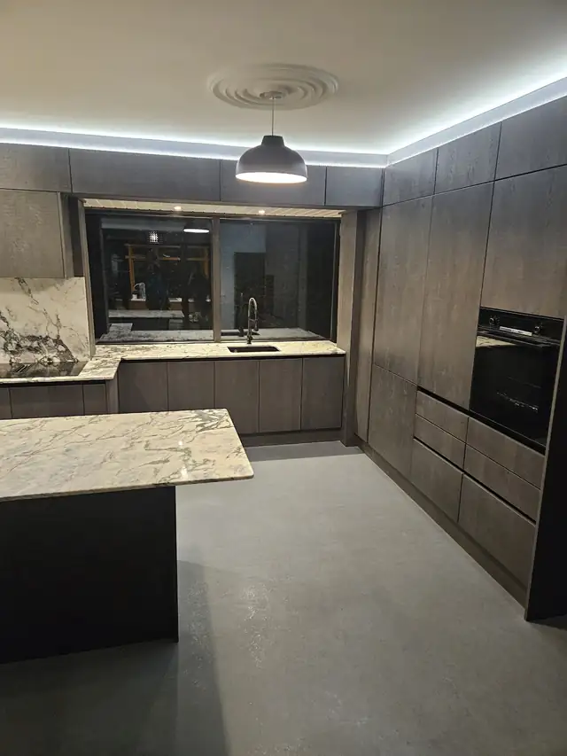 Open plan dark kitchen with island and tall units