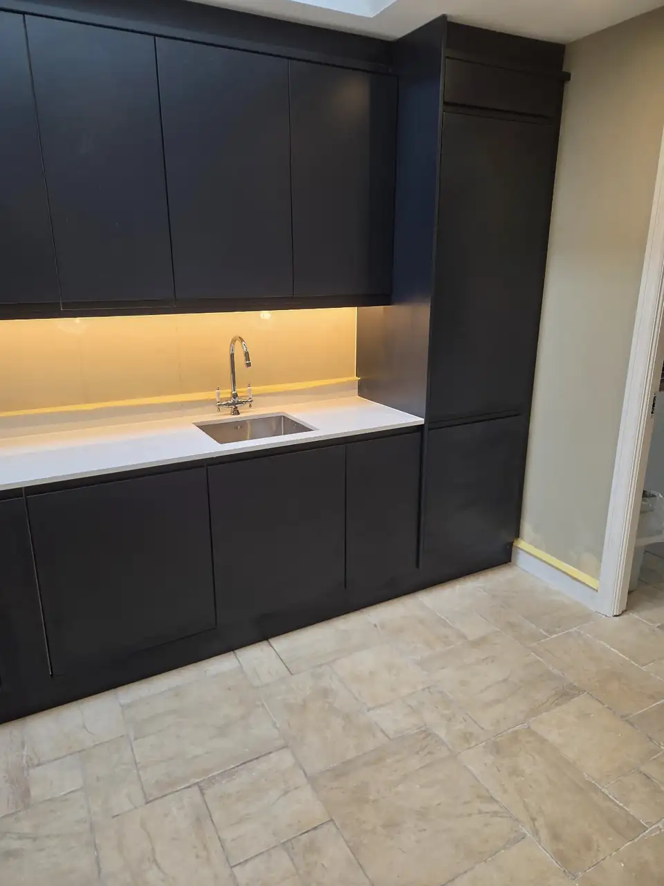 Navy shaker kitchen with white worktop and under cabinet lighting fitted by Hanlon Homes in Dublin
